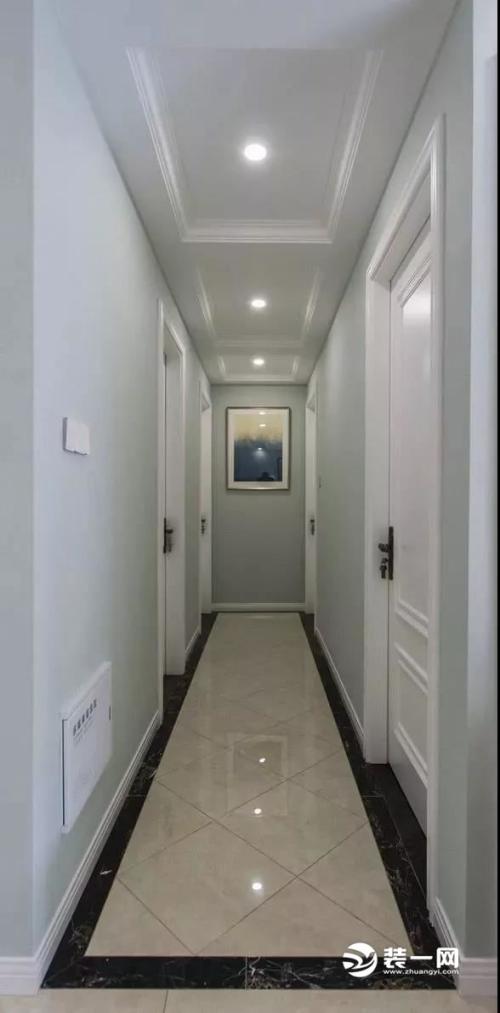 走廊风水布置设计显得非常的优雅大气,房间的地板采用的是白色的瓷砖